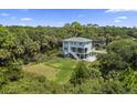 Beautiful home from an aerial perspective, surrounded by lush greenery and a large lawn at 912 Cheehaw St, Edisto Island, SC 29438