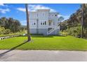 Charming two-story home with light-blue siding, an American flag and a manicured lawn at 912 Cheehaw St, Edisto Island, SC 29438