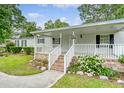 Inviting front porch with brick stairs and white railings and a well maintained front yard at 1210 Azalea Dr, Summerville, SC 29483