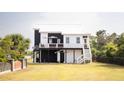 Beautifully landscaped home featuring a bright exterior, outdoor deck, and well-maintained lawn at 126-C Jungle Rd, Edisto Beach, SC 29438