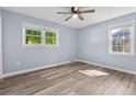 Bright bedroom features two windows, ceiling fan, and wood-look flooring at 1383 W Lenevar Dr, Charleston, SC 29407