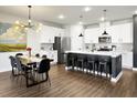 Modern kitchen with stainless steel appliances, island with bar seating, and stylish lighting fixture at 1441 Arabella St, Charleston, SC 29414