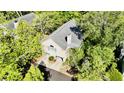 Aerial view of a home surrounded by mature trees, lush landscaping, and a two-car garage at 1551 Ben Sawyer Blvd # 23, Mount Pleasant, SC 29464