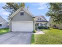 Home featuring a two-car garage, a well-manicured lawn, and classic exterior shutters at 1572 Pixley St, Charleston, SC 29414