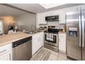 A well-lit kitchen featuring stainless steel appliances, white cabinetry and tiled floors at 2901 Dove Haven Ct # C, Charleston, SC 29414