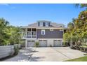 Home featuring a three car garage, covered porch, and well maintained landscaping at 314 Commonwealth Rd, Mount Pleasant, SC 29466