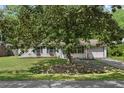 Charming single-story home with brick exterior, mature trees, and a well-manicured lawn at 323 Millcreek Dr, Charleston, SC 29407