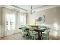 Light-filled dining room with stylish chandelier, decorative mirror and seating for six at 538 Richfield Way, Summerville, SC 29486