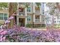 Multi-story condo building with balconies surrounded by mature trees and landscaping at 700 Daniel Ellis Dr # 4107, Charleston, SC 29412
