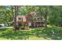 Traditional brick home with a welcoming front porch, mature landscaping, and a lush green lawn at 8661 Laurel Grove Ln, North Charleston, SC 29420