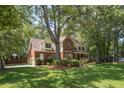 Traditional brick home surrounded by mature trees, landscaping and a lush green lawn at 8661 Laurel Grove Ln, North Charleston, SC 29420