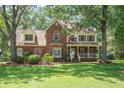 Two-story brick home with dormer windows, a front porch, mature trees, and a well-maintained lawn at 8661 Laurel Grove Ln, North Charleston, SC 29420