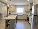 Modern kitchen with stainless steel appliances, center island, white cabinets, and farmhouse sink at 912 Kincade Dr Dr, Mount Pleasant, SC 29464