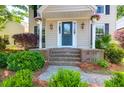 Inviting front porch with decorative plants and a stylish front door, showcasing curb appeal at 1001 Foxcroft Rd, James Island, SC 29412