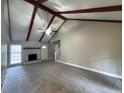 Spacious living room featuring vaulted ceilings, exposed beams, and a brick fireplace at 106 Pelican St, Ladson, SC 29456