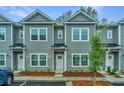 Well-lit gray townhomes feature classic design, white trim, and manicured landscaping at 1202 Twin Rivers Dr, Wando, SC 29492