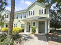 Exterior view of the two-story home featuring light green siding and a covered porch with a walkway at 1225 Blakeway St # 703, Charleston, SC 29492