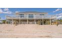 Beach house elevated with dune fencing and wide porch at 128 Palmetto Blvd, Edisto Beach, SC 29438