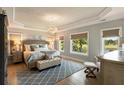Bright main bedroom with tray ceilings, hardwood floors, and large windows offering scenic views at 15 Edgewater Aly, Isle of Palms, SC 29451