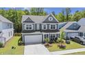 Two-story home with a two-car garage, mature trees, landscaping, and a well-maintained lawn at 160 Cherry Grove Dr, Summerville, SC 29483