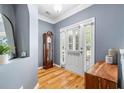 Elegant entryway features hardwood floors, soft blue walls, a stylish mirror, and an interior glass storm door at 1817 Towne St, Johns Island, SC 29455