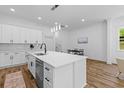 Bright kitchen has white cabinets, stainless steel appliances, an island with seating and views into an adjacent dining area at 1917 Jason St, North Charleston, SC 29406