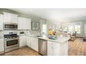 Bright kitchen with stainless steel appliances, granite countertops, and wood floors open to the living room at 216 Yalton St, Summerville, SC 29486