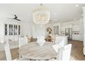 Bright open-concept dining area with modern chandelier and access to kitchen at 220 Callibluff Dr, Summerville, SC 29486