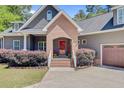 Beautiful home exterior featuring a brick entrance, red front door, and meticulous landscaping at 225 Ridge Rd, Ridgeville, SC 29472