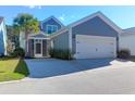 Home exterior featuring a spacious garage, screened porch, palm tree, and well-manicured lawn at 2909 Swamp Sparrow Cir, Johns Island, SC 29455