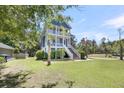 Beautiful blue two-story house featuring a manicured lawn and lush landscaping at 2919 Zachary George Ln, Johns Island, SC 29455