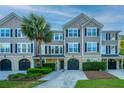 Charming townhome exterior with grey siding, black shutters, well-manicured landscaping, and private garages at 2954 Woodland Park Dr, Mount Pleasant, SC 29466