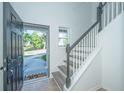 Bright foyer with staircase, light grey steps, white railings, and a glimpse of the outdoors at 2954 Woodland Park Dr, Mount Pleasant, SC 29466