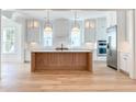 Bright, modern kitchen with a wooden center island, stainless steel refrigerator, and sleek white cabinets at 3894 Summerton St, Mount Pleasant, SC 29466
