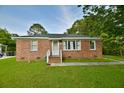 Single-story brick home with a well-kept lawn and inviting front porch at 406 Annette Dr, Goose Creek, SC 29445