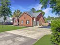 Brick home featuring a two-car garage and spacious driveway, set on a well-maintained lot at 5505 Indigo Makers Trce, Charleston, SC 29418