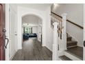 Bright foyer featuring hardwood floors, a staircase with white railings, and an archway leading to the living area at 558 Wynfield Forest Dr, Summerville, SC 29485