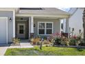 Close-up of home's entry with well-kept lawn, flower bed, and charming front porch at 629 Snow Owl Dr, Summerville, SC 29486