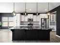 Modern kitchen features black island with marble top, white cabinets, and stainless steel appliances at 629 Snow Owl Dr, Summerville, SC 29486