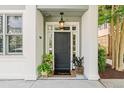 Inviting front entrance featuring a stylish black door, sidelights, transom window and potted plants at 656 Coleman Blvd # 405, Mount Pleasant, SC 29464