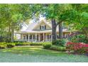 Picturesque home with a sprawling lawn, vibrant azaleas, and a classic covered front porch at 707 Royall Ave, Mount Pleasant, SC 29464