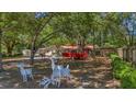 Large, tree-shaded backyard with deer lawn art, a red trailer, and potential for outdoor activities at 1010 Black Oak Rd, Bonneau, SC 29431