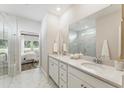 Elegant bathroom featuring double vanity, marble countertops, and a glass-enclosed shower at 1021 Sagegrass Street, Summerville, SC 29485