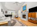 Bright and airy living room featuring a fireplace, wood floors, and vaulted ceilings with a skylight at 1116 Daffodil Ln, Mount Pleasant, SC 29464
