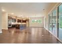 Open-concept living area with brick accents in the kitchen, hardwood floors, and access to an outdoor patio at 1212 Reserve Ln, Awendaw, SC 29429