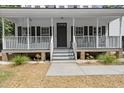 Inviting front porch with classic white railings and an entryway with a dark-colored front door at 1260 Old Whitesville Rd, Moncks Corner, SC 29461