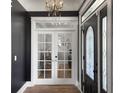 Elegant entryway with hardwood floors, chandelier, french doors and decorative front door at 127 Beresford Creek St, Daniel Island, SC 29492