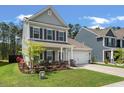 Charming two-story home with a manicured front yard, covered porch, and attached garage, offering curb appeal at 127 Surfbird Rd, Summerville, SC 29486