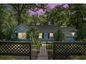 Charming single-story home at dusk with landscaped yard and black metal fence, evoking a sense of warmth at 1316 Wichman St, Walterboro, SC 29488
