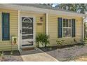 Close up view of the front of the home featuring yellow siding, blue shutters, front door with decorative glass at 1507 Blaze Ln, Charleston, SC 29412